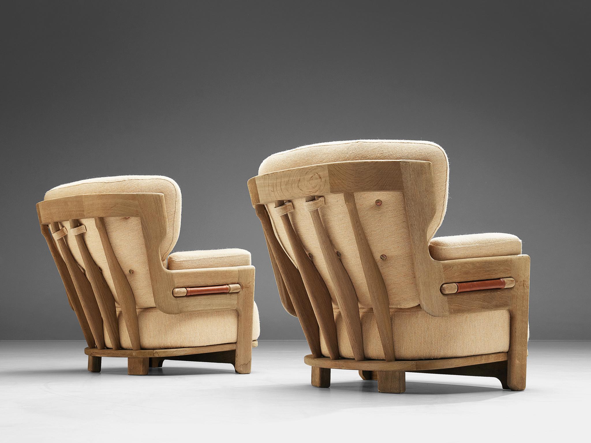 Guillerme & Chambron for Votre Maison, set of two 'Denis' lounge chairs, fabric and oak, France, 1960s.

Set of two extraordinary Guillerme and Chambron lounge chairs in solid oak with the typical characteristic decorative details at the back and