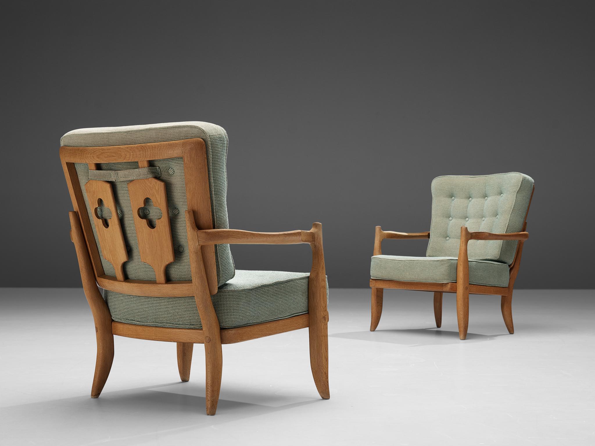 Set of two Guillerme et Chambron easy chairs, oak and green upholstery, France, 1950s

The seating as well as the backrest are made of comfortable cushions, upholstered in a warm green colored woolen fabric. Whereas the front convinces with its