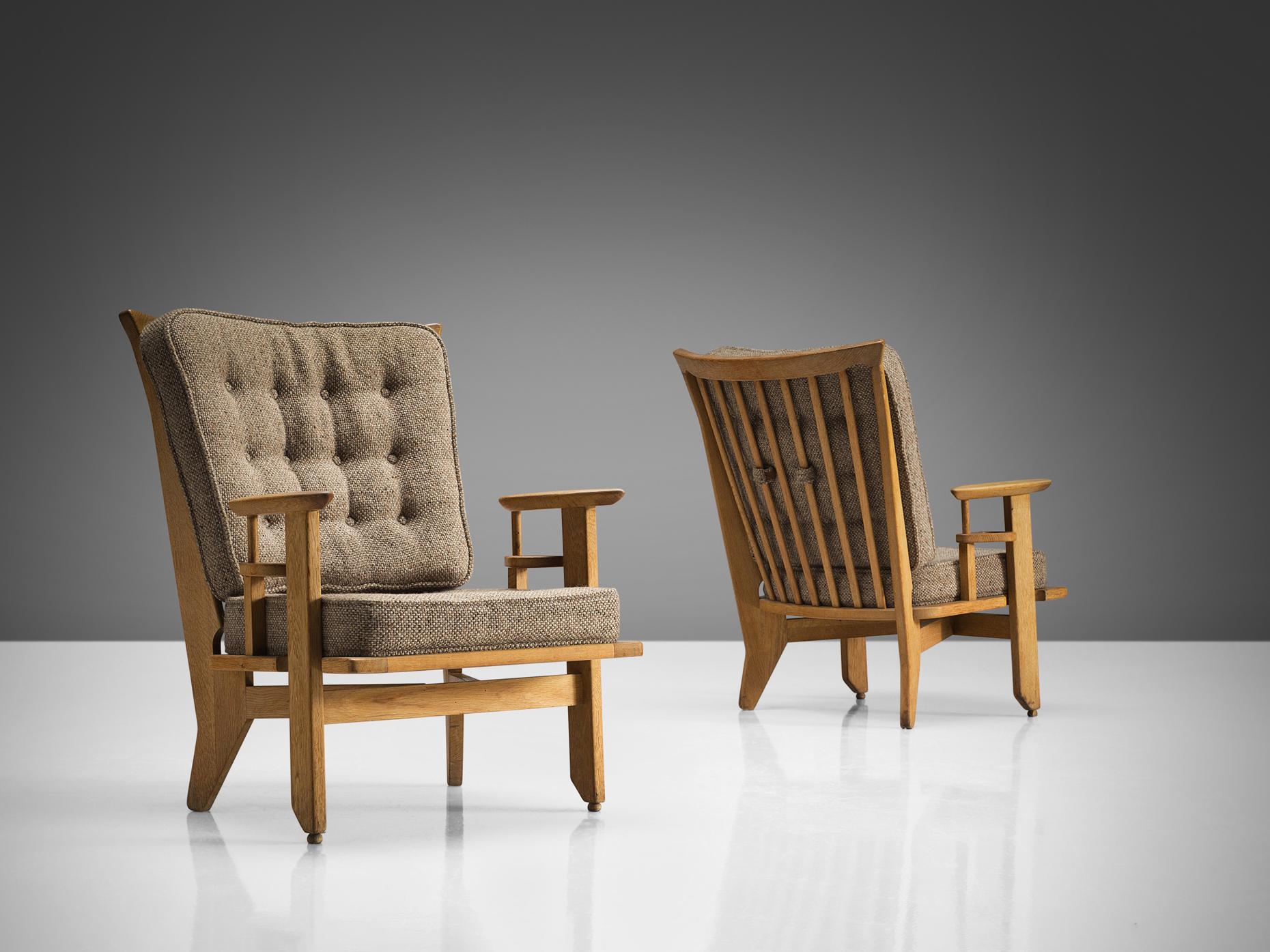 Guillerme et Chambron, pair of lounge chairs, oak, beige woolen upholstery, France, 1965. 

Sculpted Guillerme et Chambron lounge chairs in solid oak with the characteristic spindled back and tapered forms of the legs. The sculptural frame with