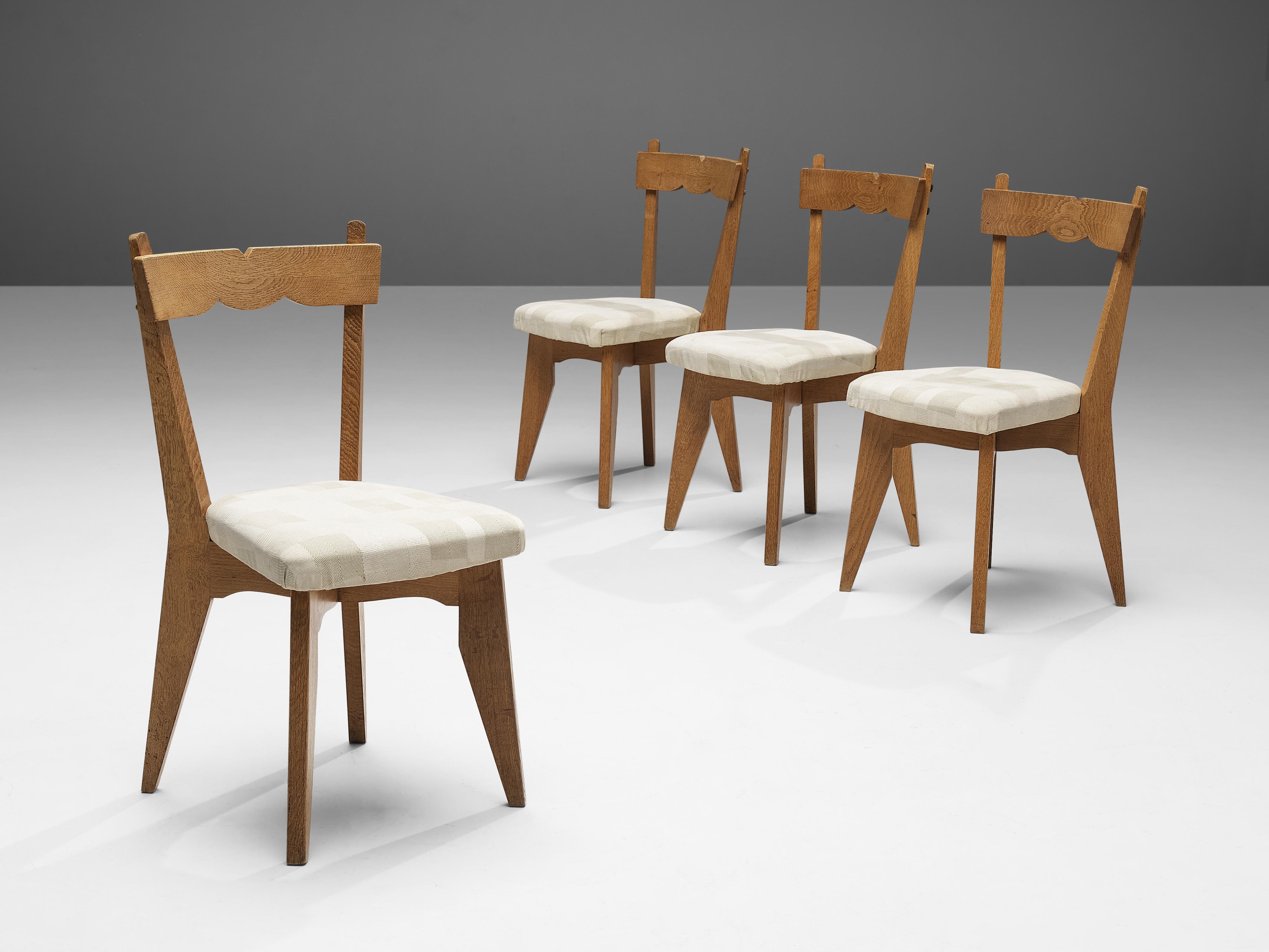 Guillerme et Chambron, set of four dining chairs, solid oak, fabric upholstery, France, 1960s

These dining chairs in solid oak are designed by the French designer duo Jacques Chambron and Robert Guillerme. On four tapered legs rests the seating