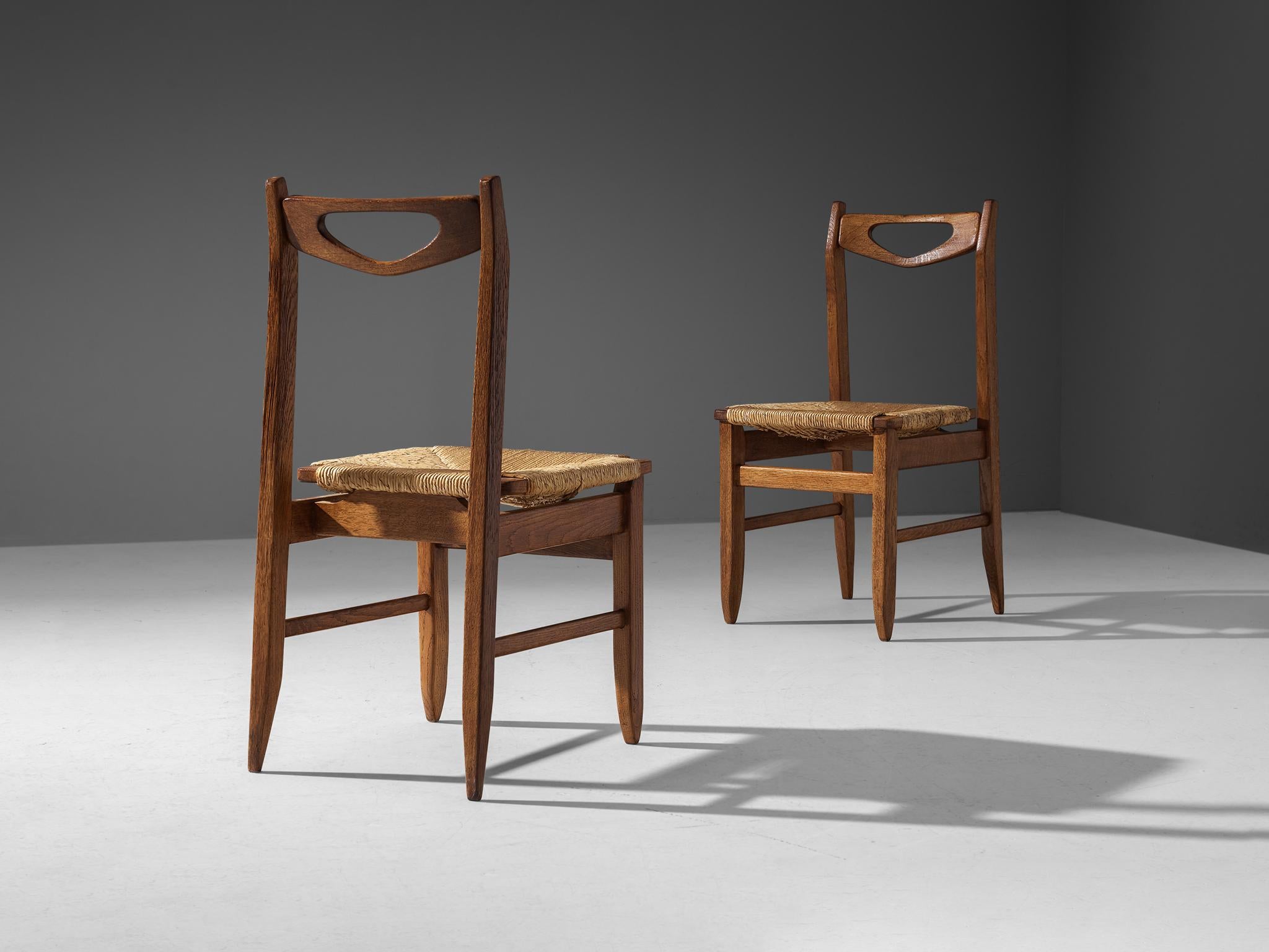 Milieu du XXe siècle Guillerme & Chambron - Ensemble de quatre chaises de salle à manger en chêne avec sièges en paille