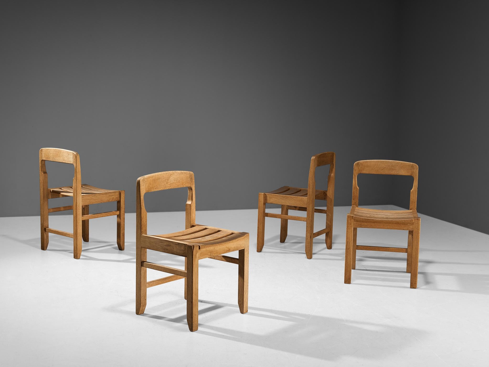 Guillerme et Chambron for Votre Maison, set of four dining chairs, solid oak, France, 1960s.

These chairs show the characteristic frame of the French designer duo, well-crafted, solid and sculptural.  The chairs feature geometrically tapered legs