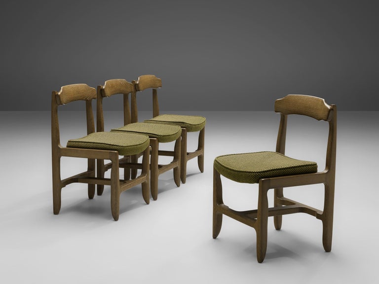 Guillerme et Chambron, set of four dining chairs, stained solid oak, fabric upholstery, France, 1960s

These dining chairs in solid oak are designed by the French designer duo Jacques Chambron and Robert Guillerme. On four tapered legs rests the