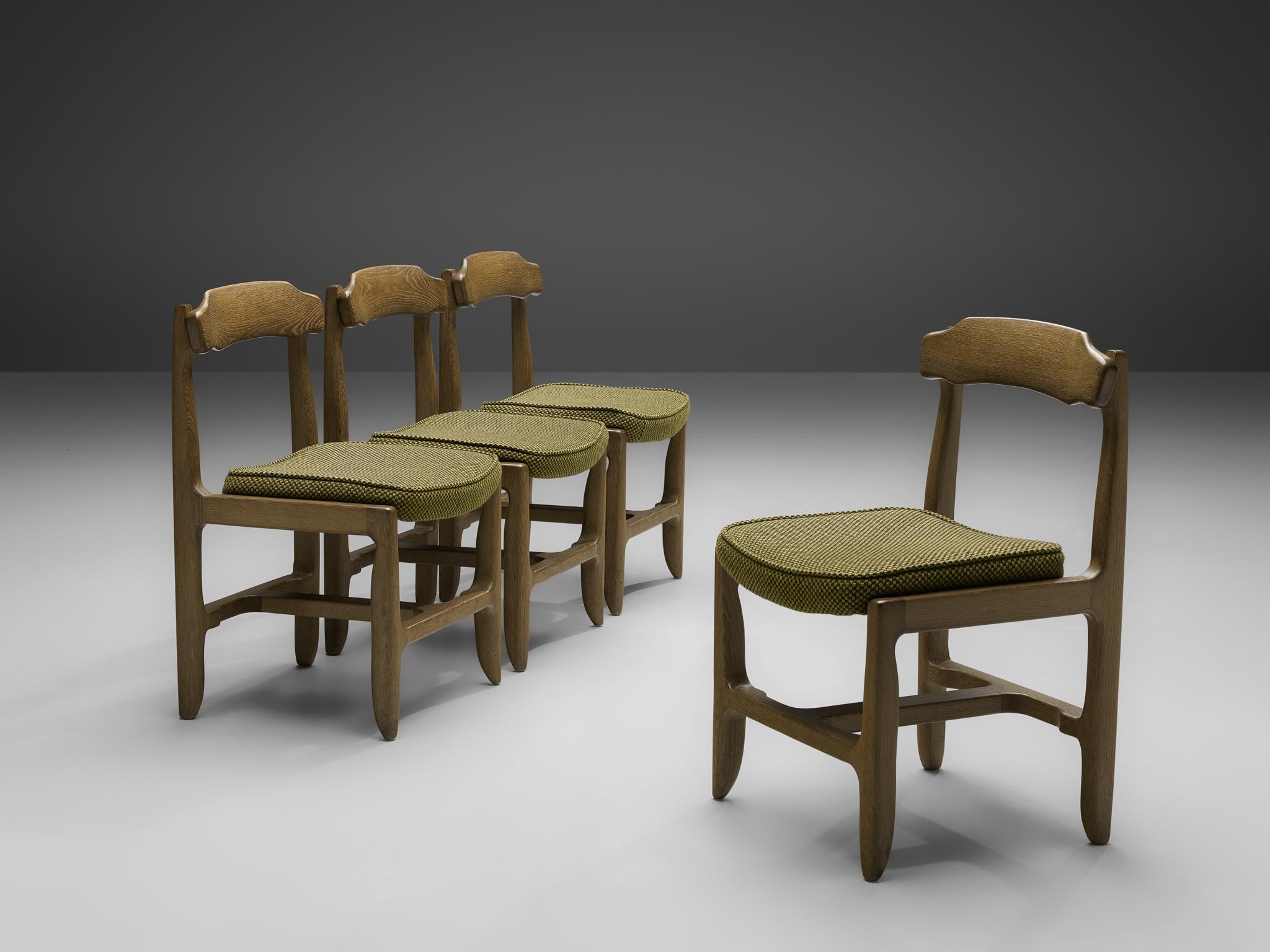 Guillerme et Chambron, set of four dining chairs, stained solid oak, fabric upholstery, France, 1960s.

These dining chairs in solid oak are designed by the French designer duo Jacques Chambron and Robert Guillerme. On four tapered legs rests the