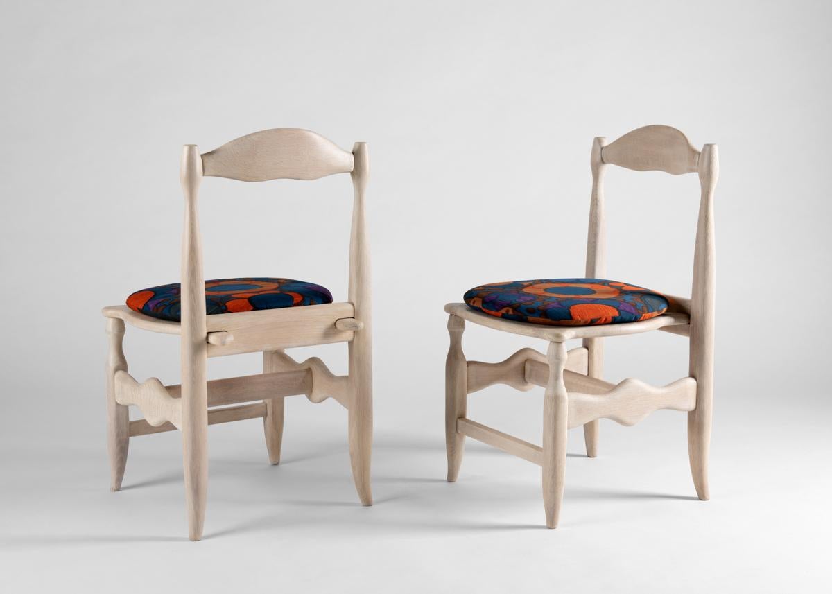 These elegant set of four limed oak dining chairs by the celebrated French designer Robert Guillerme, was created as part of a line of design he produced for the company Votre Maison.

Guillerme placed equal emphasis on function and aesthetics,