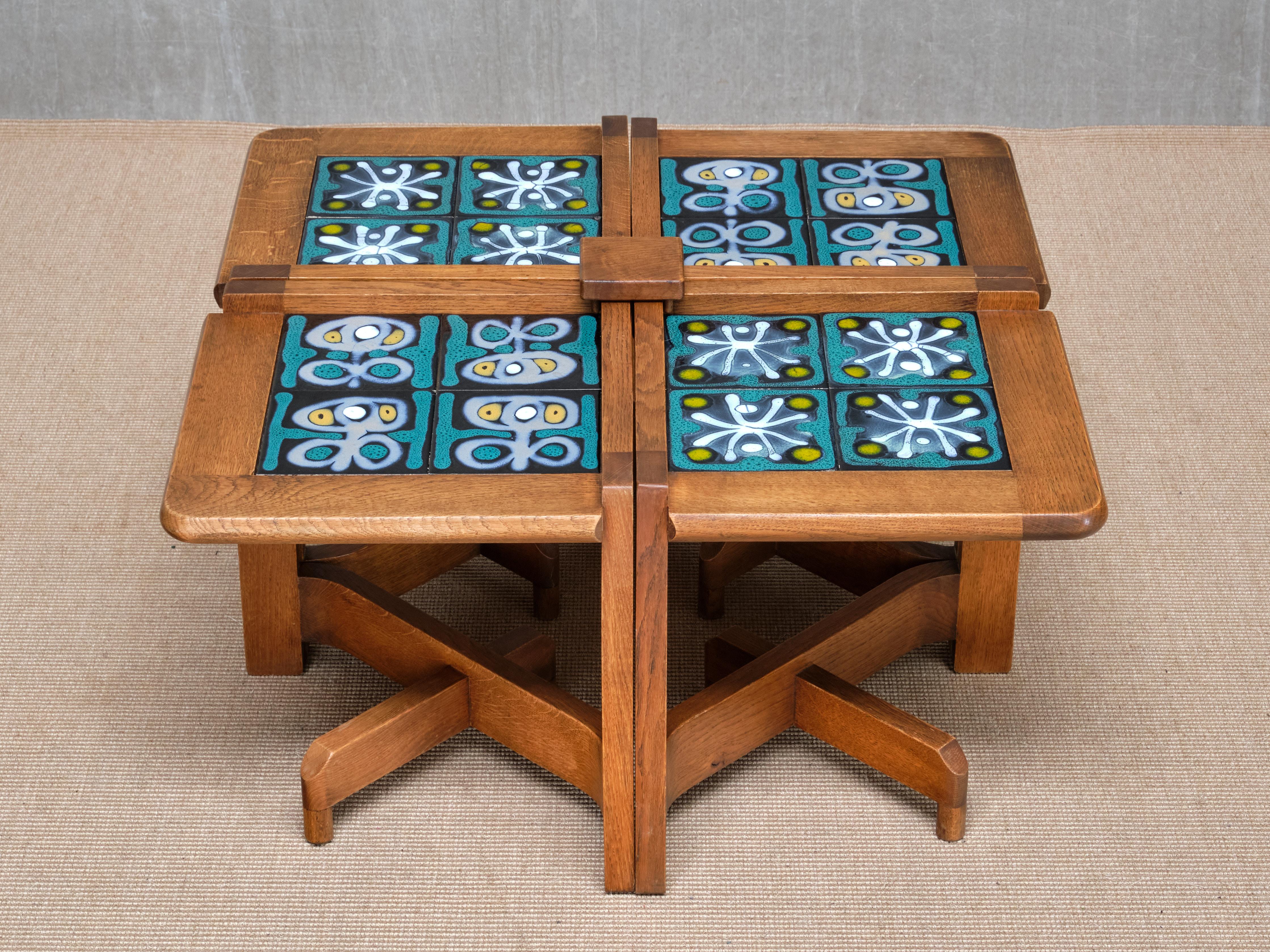 This very rare set of four solid oak side tables was designed by Guillerme et Chambron and produced by their atelier Votre Maison in Northern France in the 1950s. Each table is topped with its original hand-glazed ceramic tiles by the artist