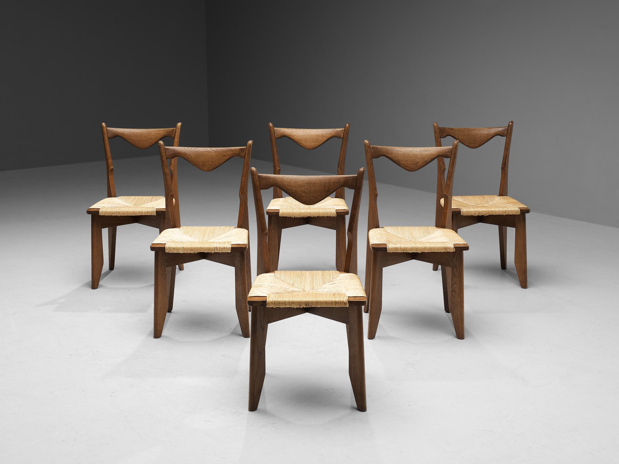 Guillerme & Chambron for Votre Maison, set of six dining chairs, oak, straw, France, 1960s

Set of six elegant dining chairs in solid oak by Guillerme and Chambron. These chairs show the characteristic frame of this French designer duo. Tapered