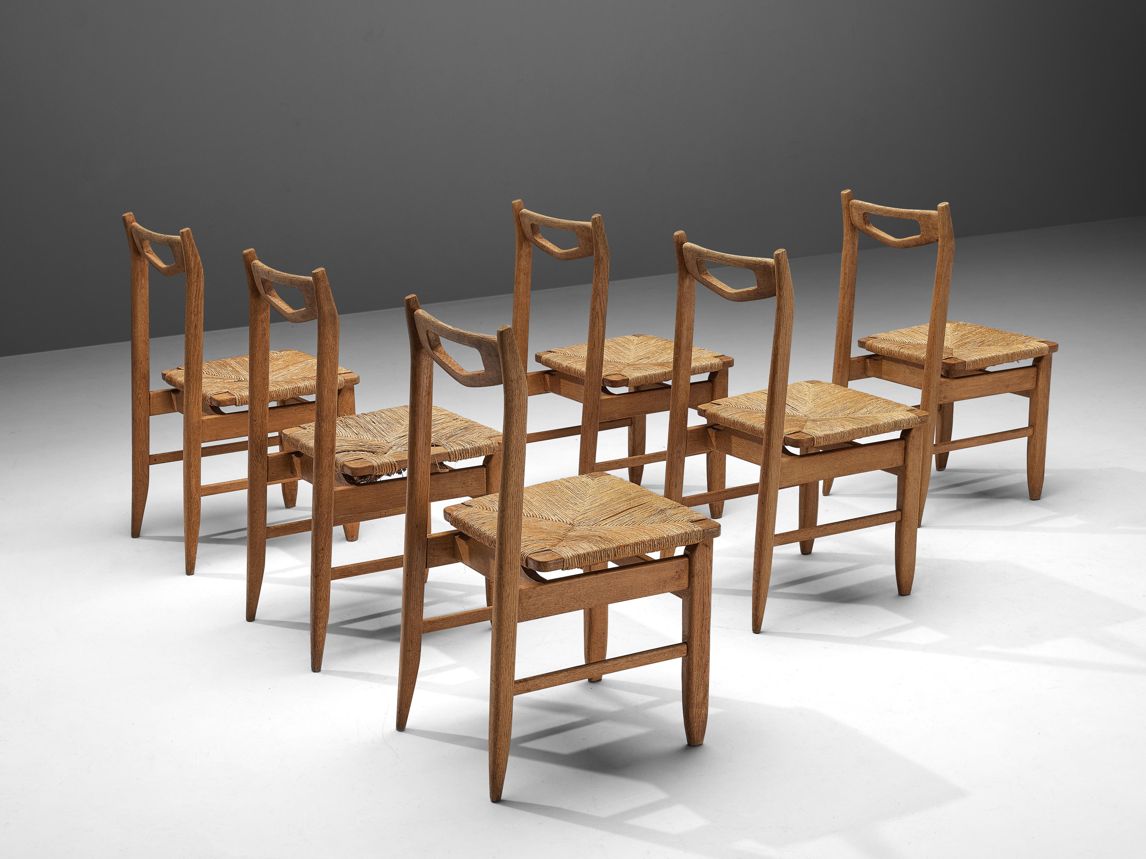Guillerme & Chambron for Votre Maison, dining chairs, oak, rush, France, 1960s

Set of six elegant dining chairs in solid oak by Guillerme and Chambron. These chairs show the characteristic frame of this French designer duo. The backrest features