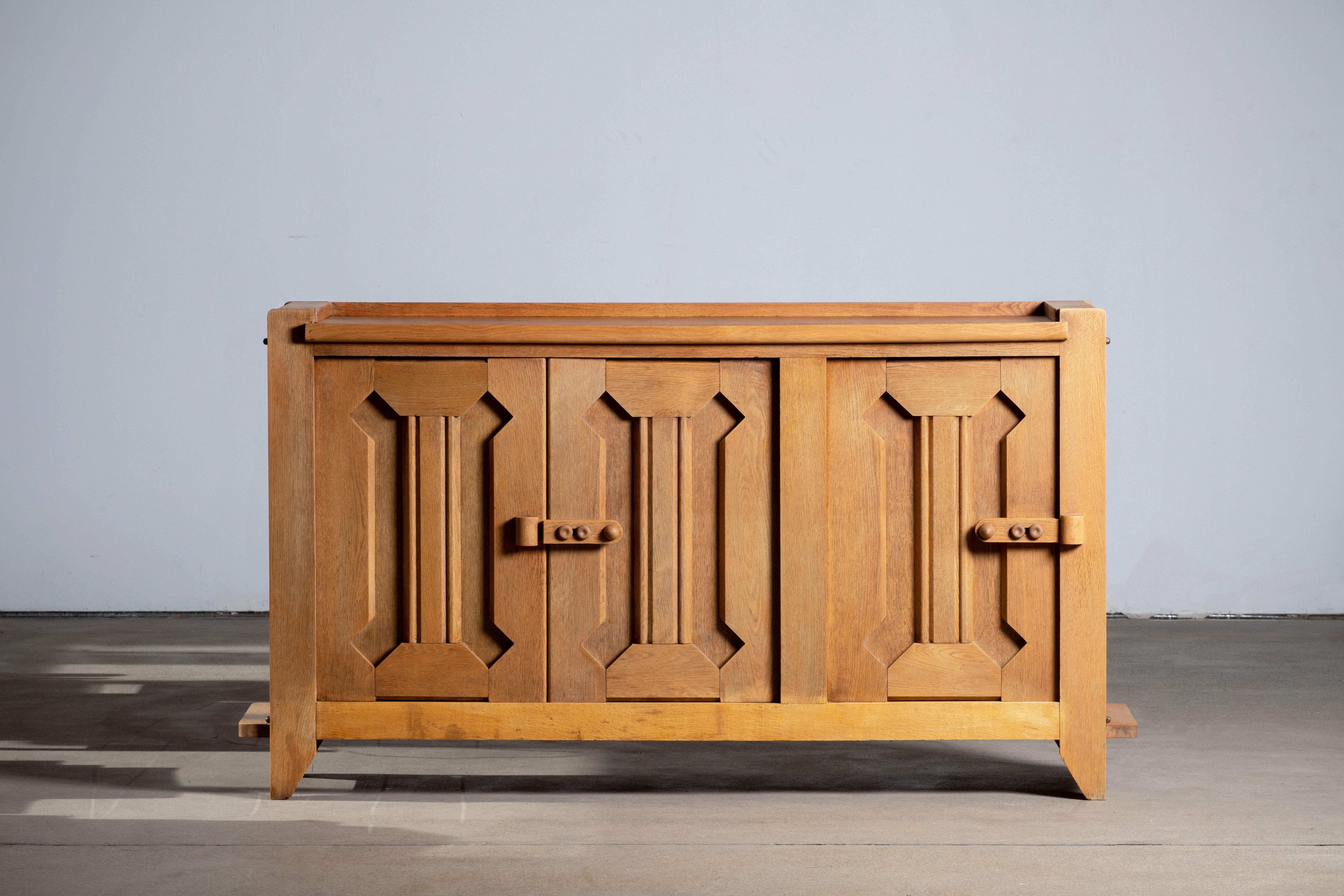 This characteristic cabinet, buffet in solid oak was designed by the French designer duo Jacques Chambron (1914-2001) and Robert Guillerme (1913-1990) . 

The French designer duo Jacques Chambron (1914-2001) and Robert Guillerme (1913-1990)