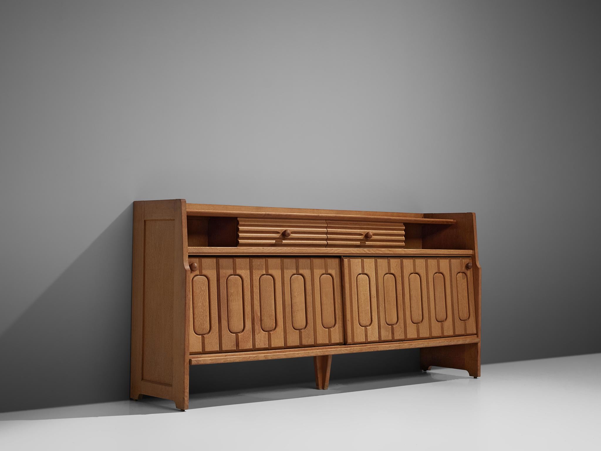 Guillerme et Chambron, sideboard, in oak and ceramic, France, 1960s.

Credenza in oak by French designer due Guillerme & Chambron. This sideboard is equipped with two sliding-doors and a set of drawers. The front of the sideboard is beautifully