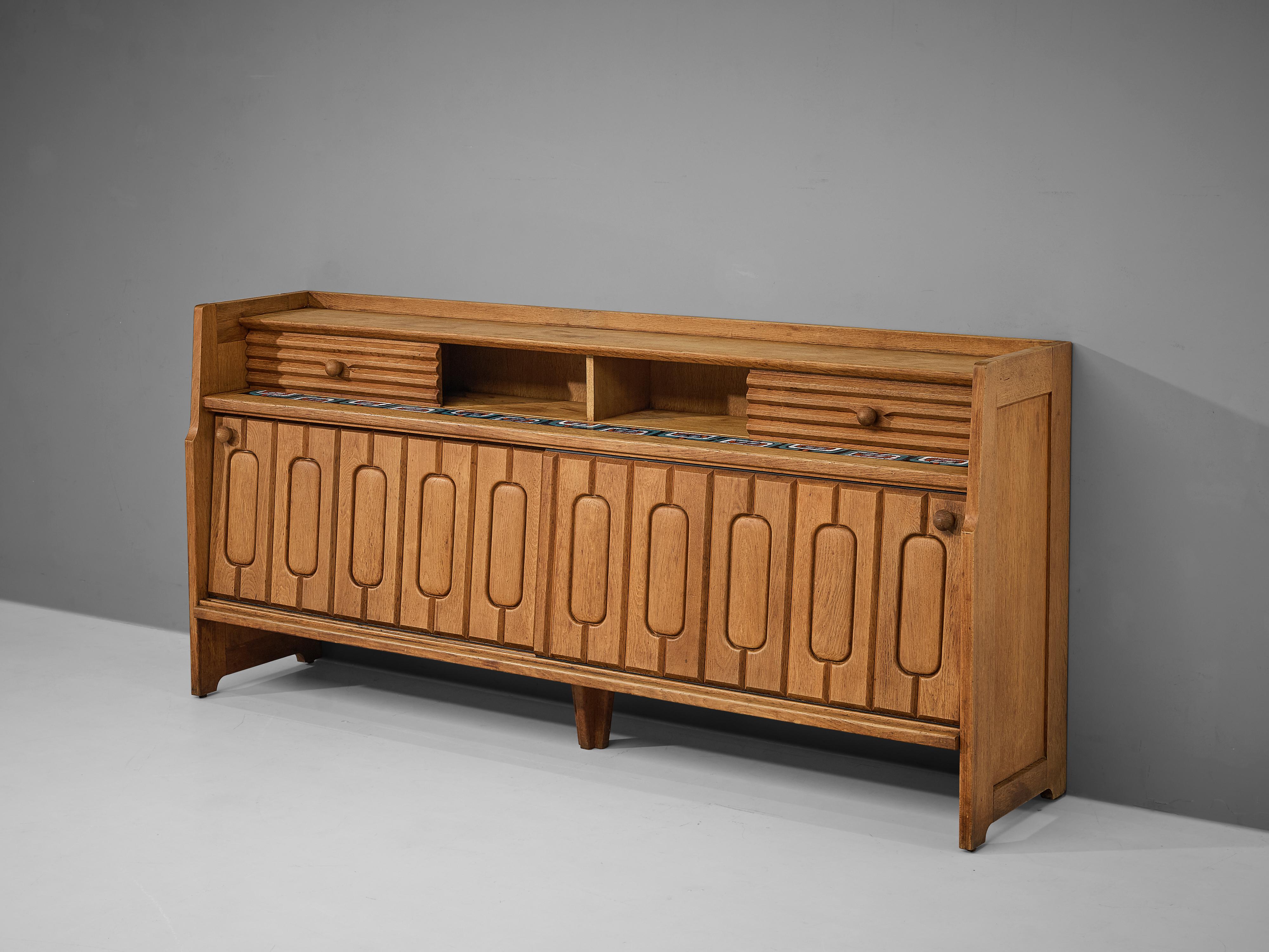 Guillerme et Chambron, sideboard, oak, ceramic, France, 1960s

Credenza in oak by French designer due Guillerme & Chambron. This sideboard is equipped with two sliding-doors and storage space on top. The front of the sideboard is beautifully