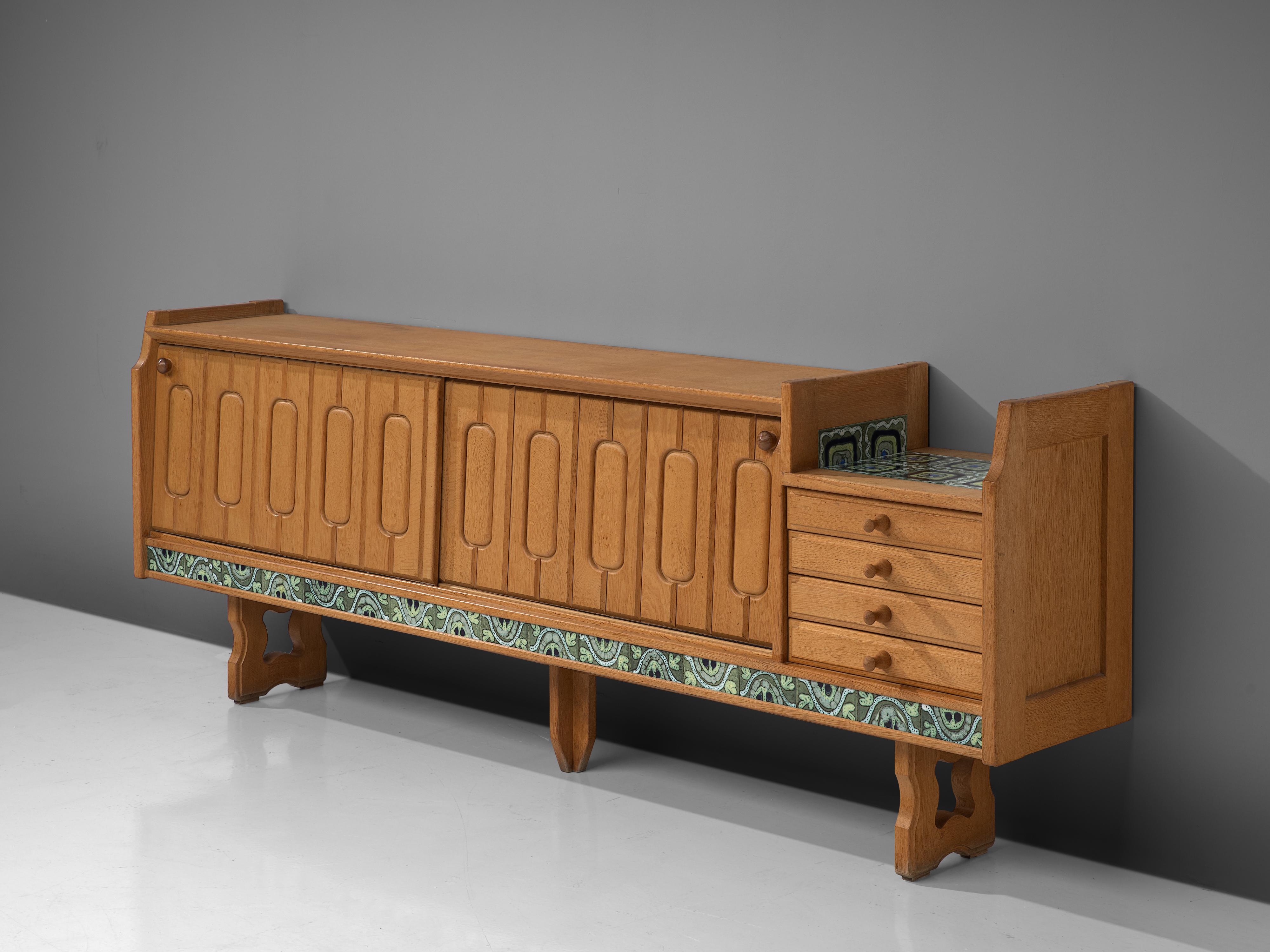 Guillerme et Chambron, sideboard model 'Simon', oak, ceramic, France, 1960s

Credenza in oak by French designers Guillerme et Chambron. This sideboard is equipped with two sliding doors and a set of drawers. The front of the sideboard is