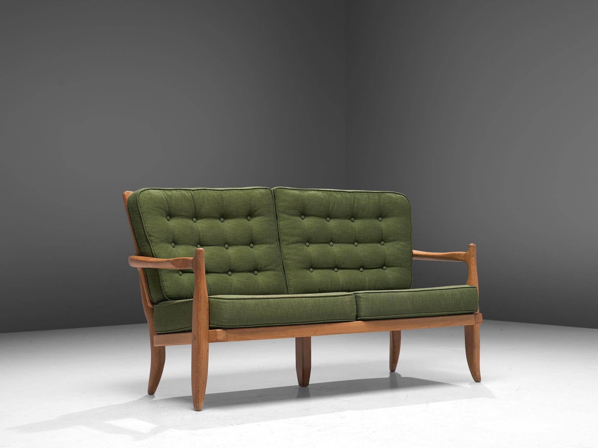 Guillerme et Chambron, sofa, oak and fabric, France, 1960s.

Beautiful two-seat settee by Guillerme and Chambron, in solid oak with the typical characteristic decorative details at the back and sculpted forms of the legs. The thick, green cushions