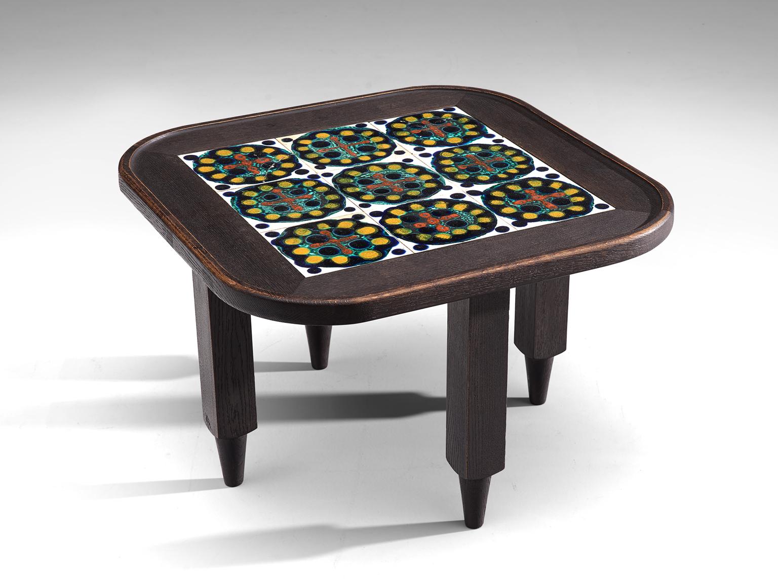 Guillerme et Chambron, coffee table, in darkened oak and ceramic, France 1960s. 

Square oak coffee table with beautiful colored ceramic tiles in the top. The materials and forms of this table show the characteristics of the French designers
