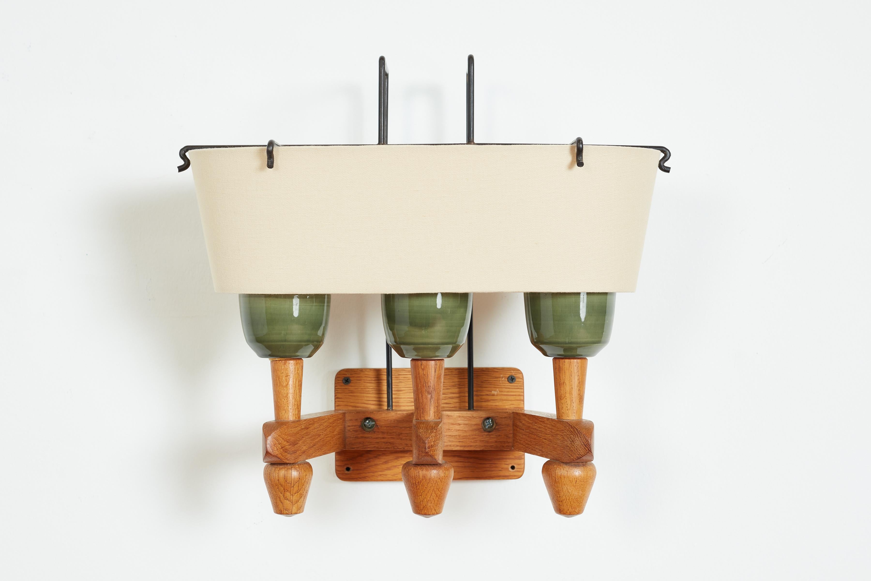 Rare wall sconce by Guillerme et Chambron - France, 1940's 
Green ceramic sockets with signature oak frame and single silk shade with black iron frame. 
Rewired. 