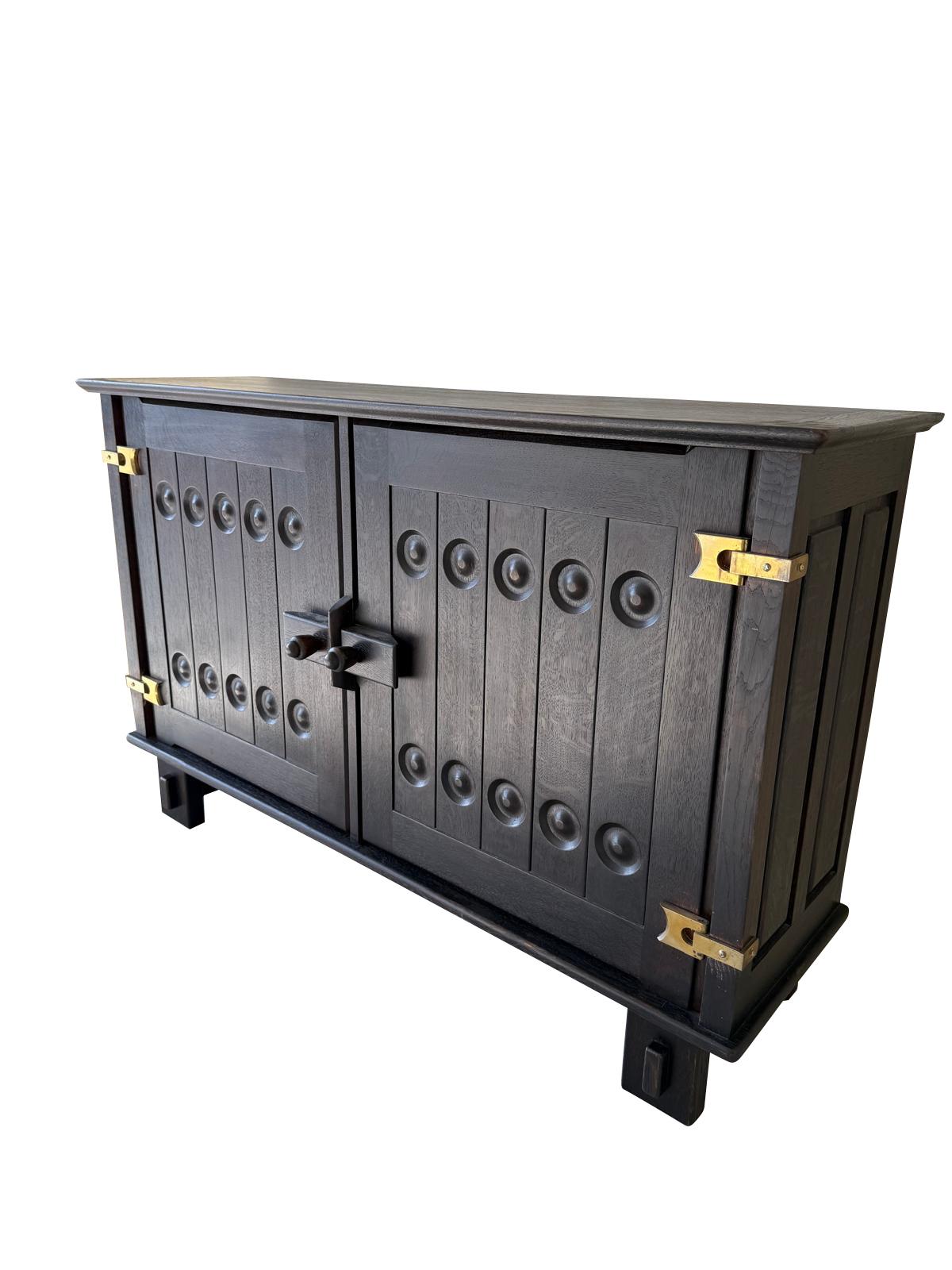 1960's French Guillerme et Chambron two door cabinet.
Ebonized type finish on open grained oak.
Decorative brass hinges and roundels on front panel doors.
SIgnature designed door closure.
Two interior shelves.
ARRIVING AUGUST