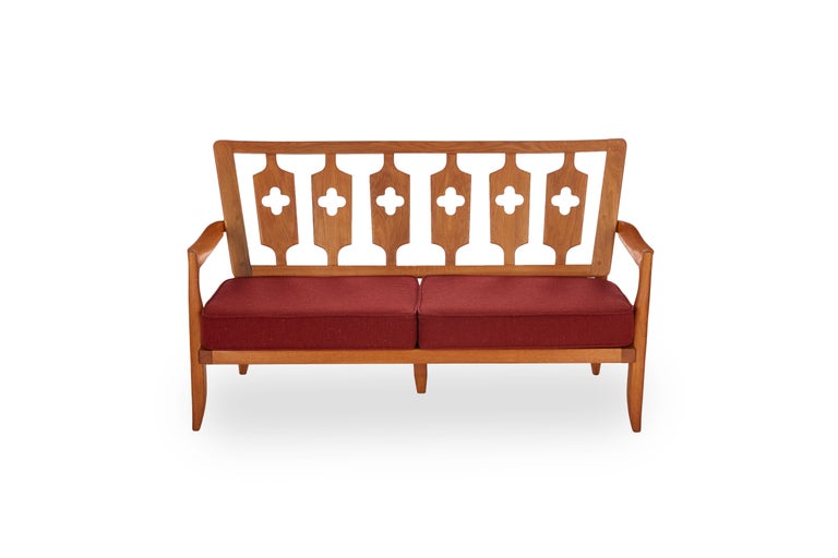 This elegant midcentury polished oak sofa by the celebrated French designer Robert Guillerme was created as part of a line of design he produced for the company Votre Maison.

Guillerme placed equal emphasis on function and aesthetics, creating an