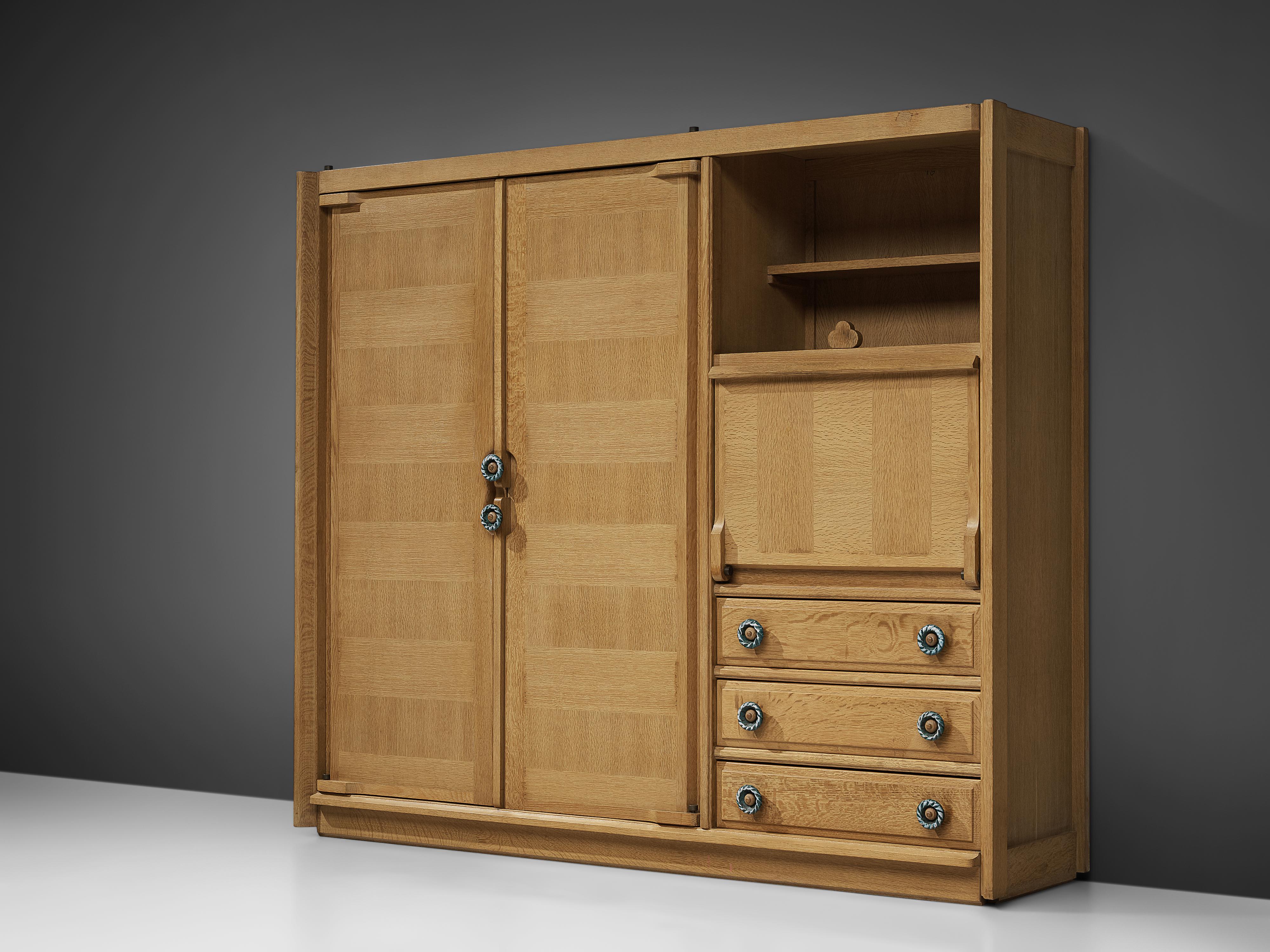 Guillerme and Chambron, cupboard, oak, ceramic, France, 1960s 

With differently designed compartments this cupboard offers many versatile features. On the one side two large doors access an interior with shelves. Next to it are drawers and a dry