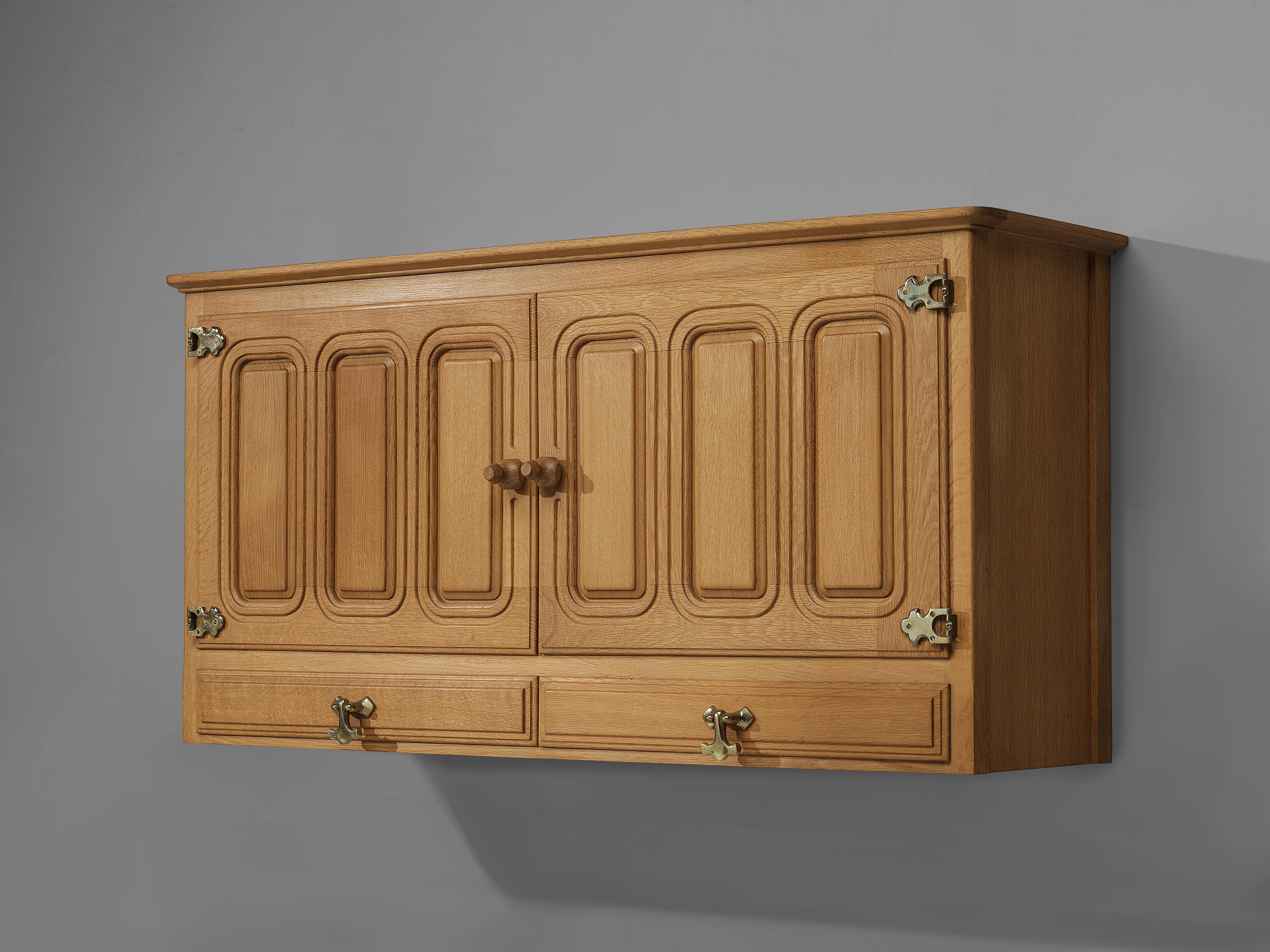 Guillerme et Chambron for Votre Maison, wall-mounted sideboard, oak, France, 1960s.

This charming wall-mounted cabinet features two door panels with geometrical wooden carvings. The cabinet offers plenty of storage such as shelves located behind