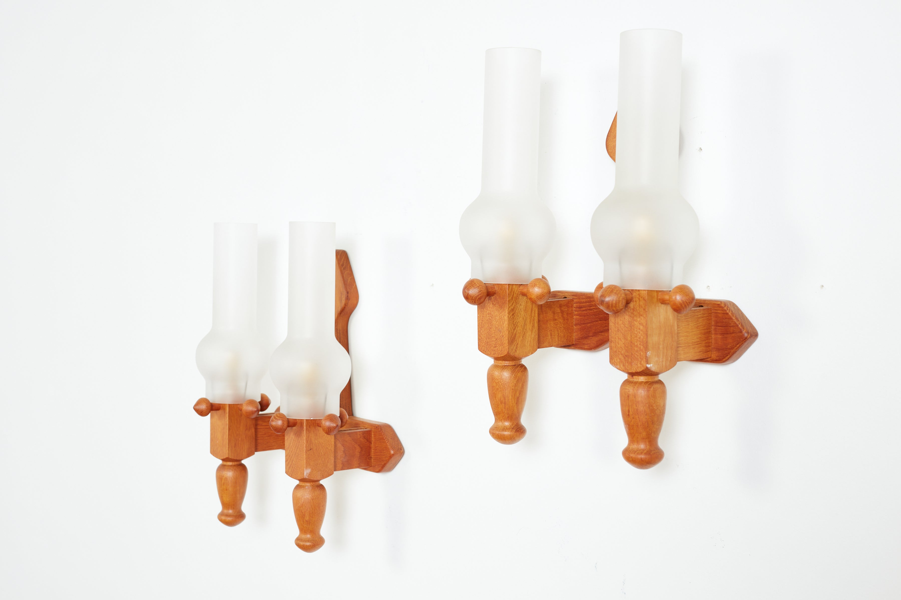 Impressive pair of double torchiere glass sconces by Guillerme et Chambron 
France, circa 1940s 
Oak frames with original hurricane milk glass shades 
Newly rewired.