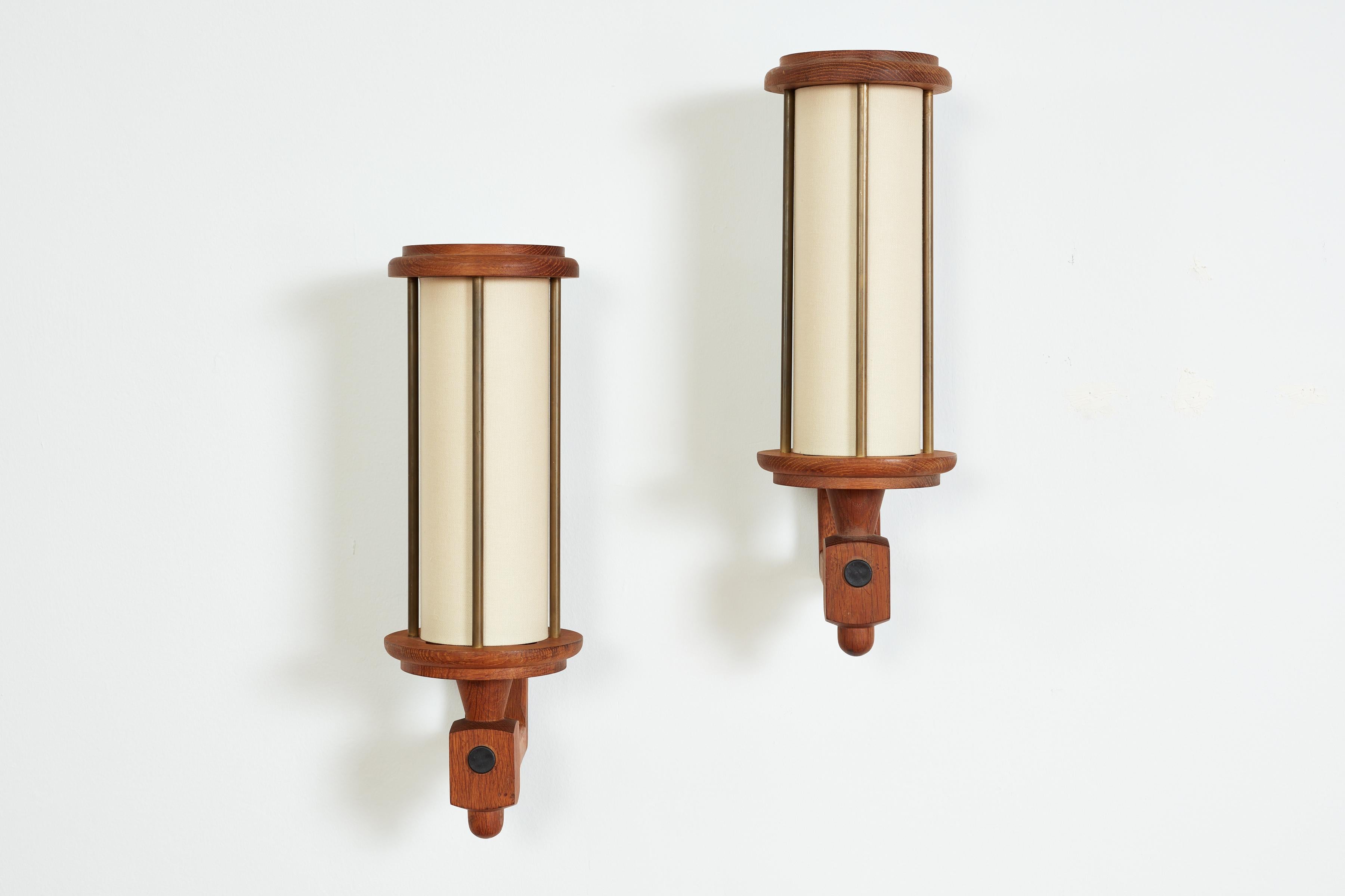Rare pair of large scale sconces by Guillerme et Chambron - France, 1960s
Oak with brass linear hardware - tubular new linen shade 
Great patina on brass
Newly rewired.