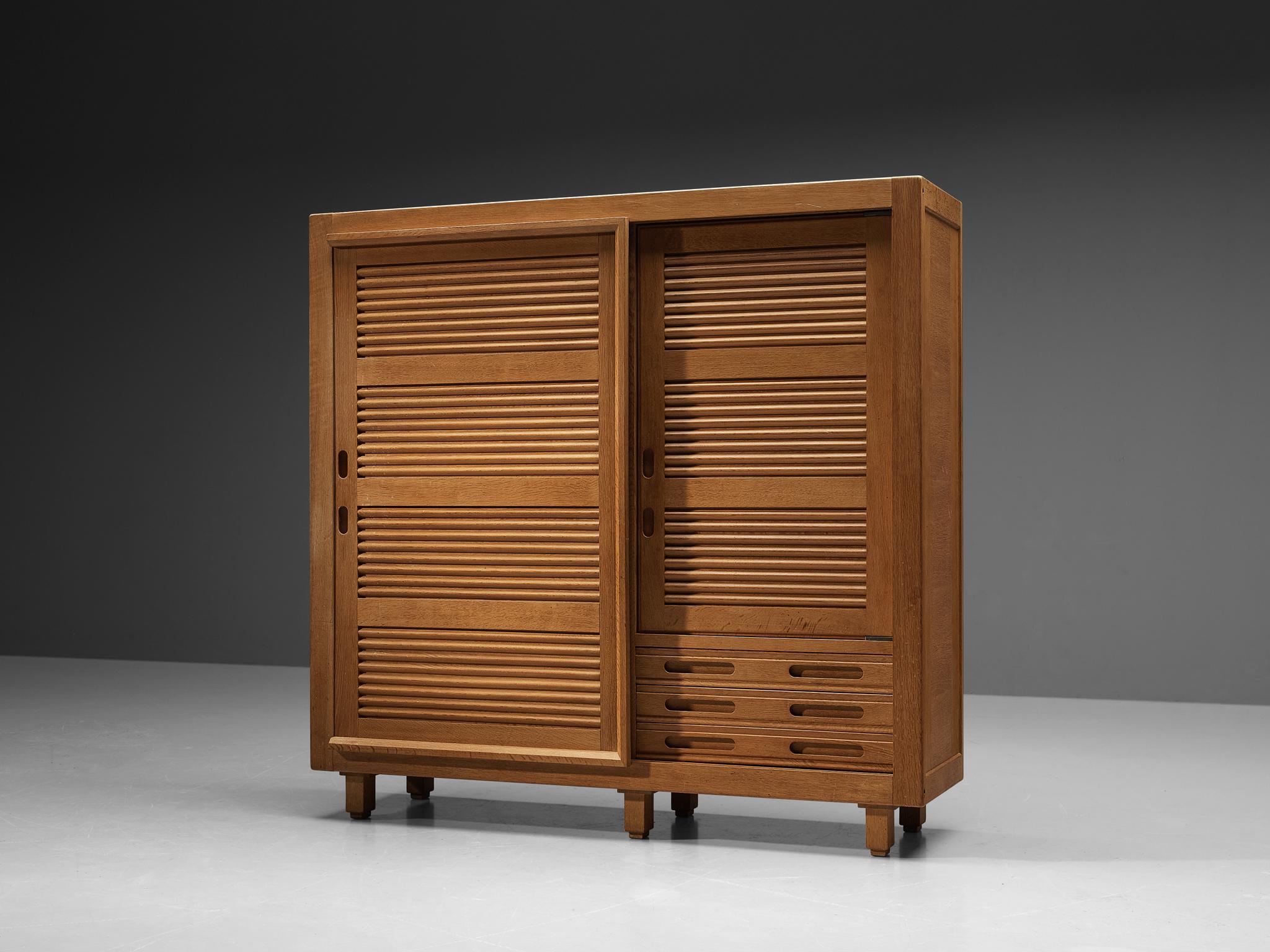 Guillerme et Chambron for Votre Maison, wardrobe, oak, France, 1960s

This case piece is designed by Guillerme and Chambron and features two vividly carved doors, which are characteristic for the French duo. The wardrobe features distinct sculptural
