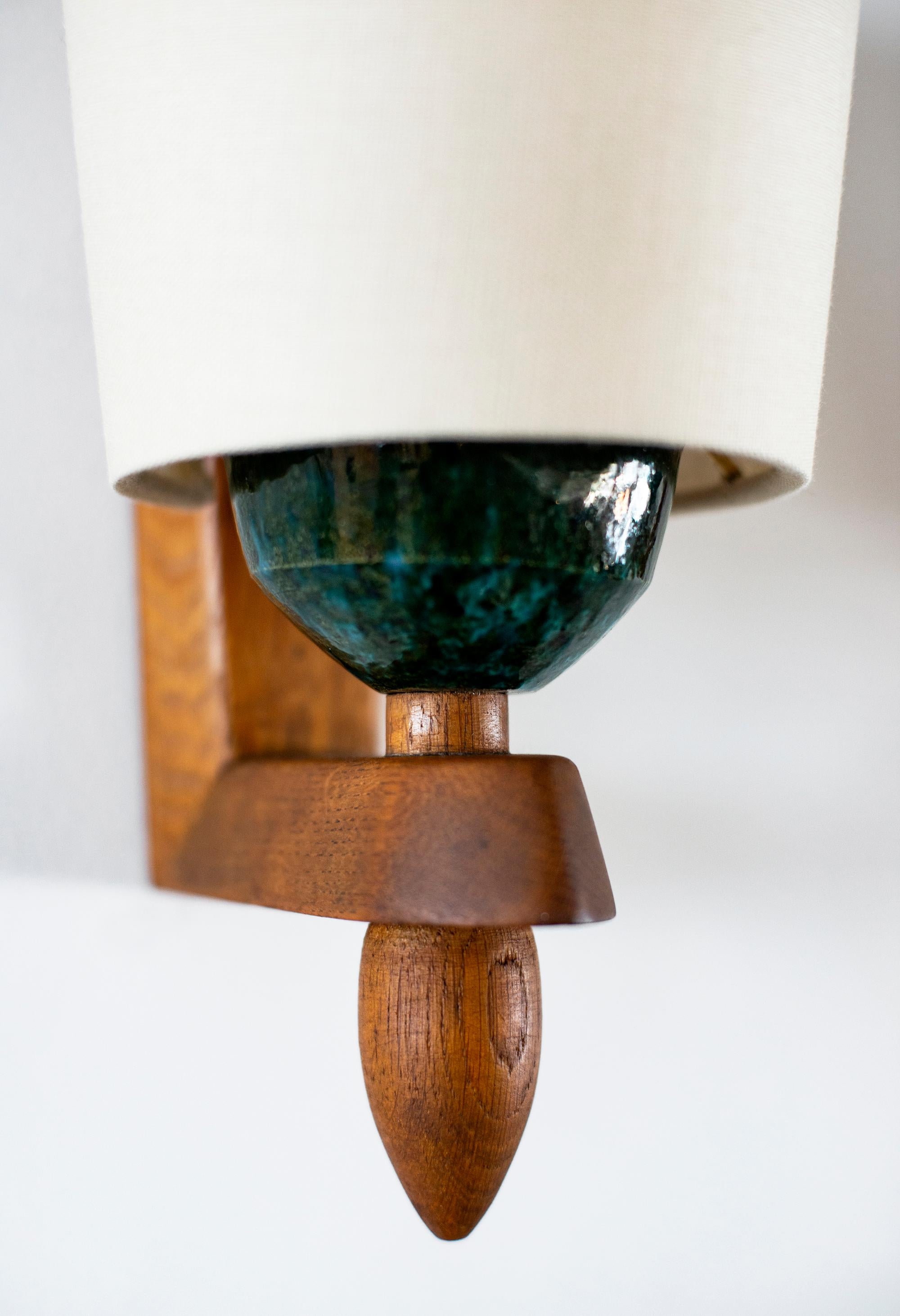 Handsome single French wall sconce in cerused oak by Guillerme et Chambron. Beautiful wood with new silk shade which rests on a turquoise ceramic socket.
Very unique design.
Newly rewired.
 