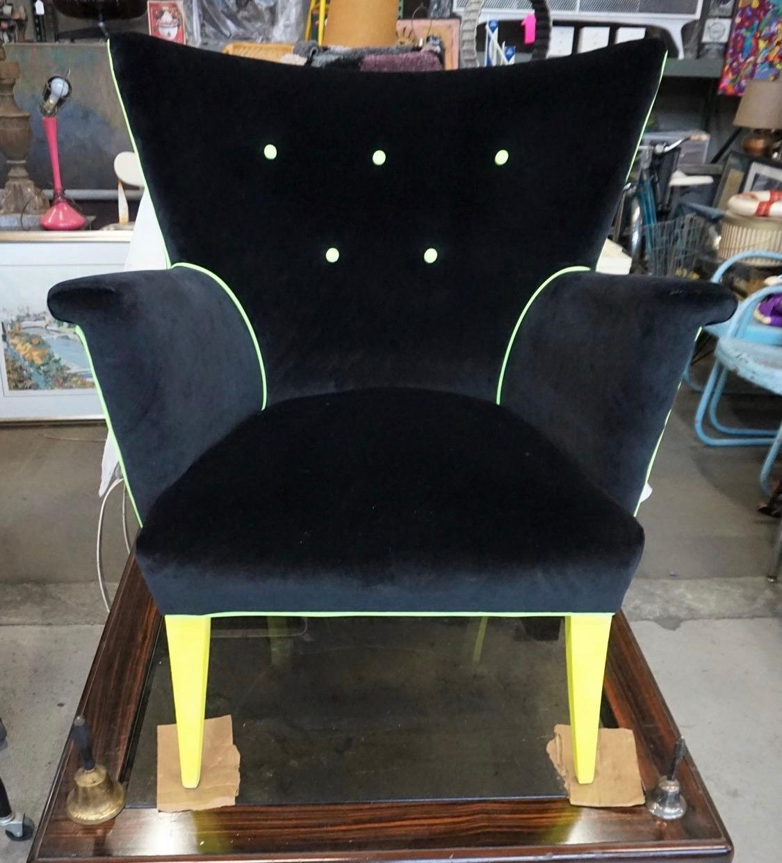 Chaise à oreilles Guillermo nouvellement retapissée, et chaise iconique Hollywood Regency. Le tissu principal est du velours noir et il y a aussi un éclat de passepoil jaune fluo. C'est un fauteuil très confortable. Aujourd'hui, plus que jamais,