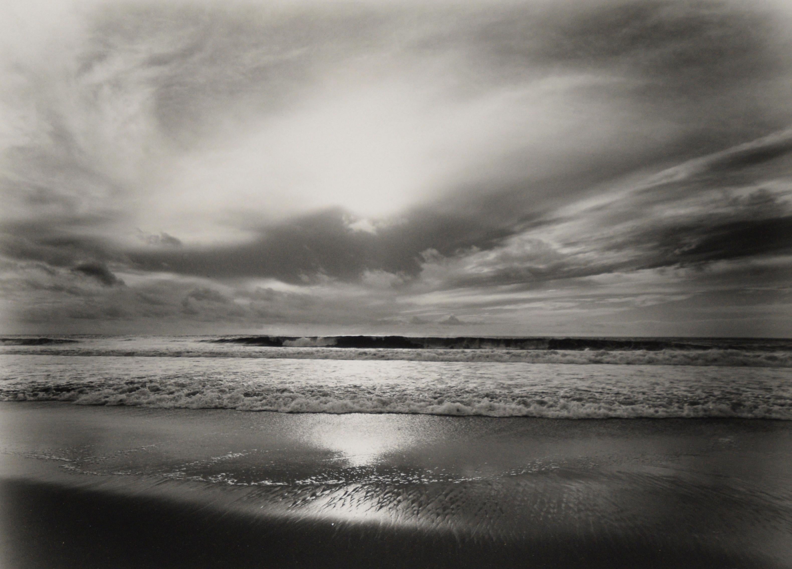 Manhattan Beach, 2003 - Original Black and White Photograph

Original black and white photograph of Manhattan Beach, California by Guillermo Zuniga (American). The viewer looks towards the ocean as waves are crashing ashore. The sun shines through