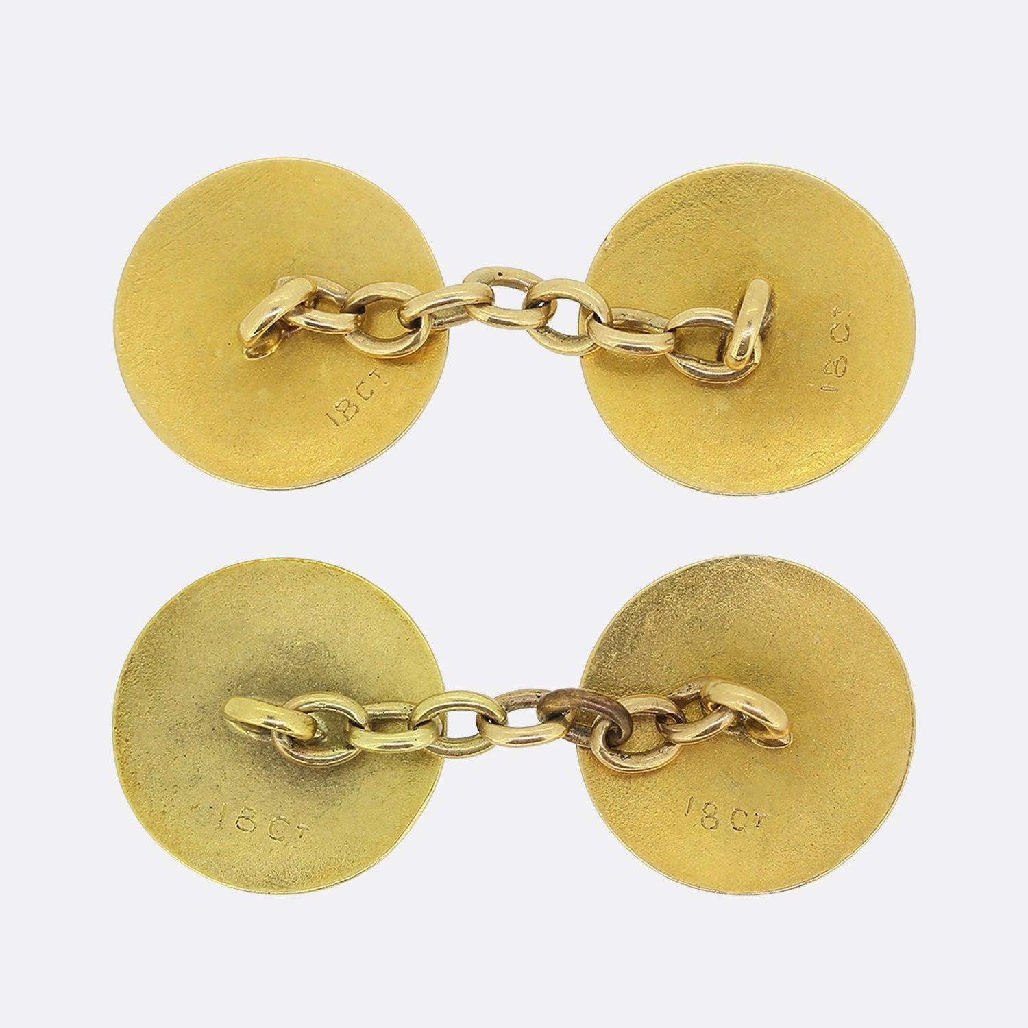 Si tratta di un paio di gemelli a catena in oro giallo 18ct. I gemelli da polso sono stati realizzati in forma circolare e il disegno di ogni faccia viene ricambiato all'estremità opposta. La smaltatura guilloché blu intenso domina il centro, mentre