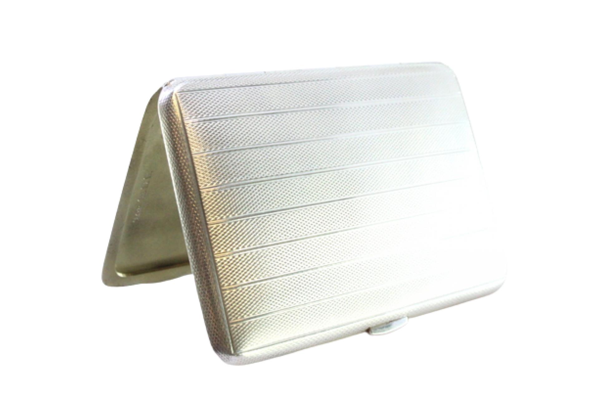 Description : Etui à cigarettes en argent guilloché avec bandes sur le dessus et couvercle à charnière. Métal : Argent. Origine : Anglais. Marque : Londres. Poids : 83,41 grammes. Dimensions : 8,5 cm x 6 cm : 8,5cm x 6cm. Contenu : 925/1000. Marque
