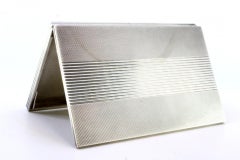 Guilloche silver cigarette case with bands at the top, hinged lid and gold clasp