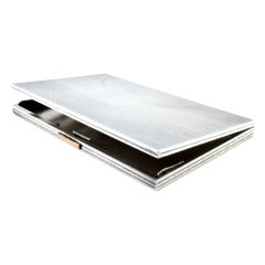 Guilloche silver cigarette case with bands at the top, hinged lid and gold clasp