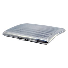 Guilloche silver cigarette case with curved bands at the top and hinged lid