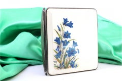 Guilloche silver cigarette case with enameled hinged lid featuring blue flowers