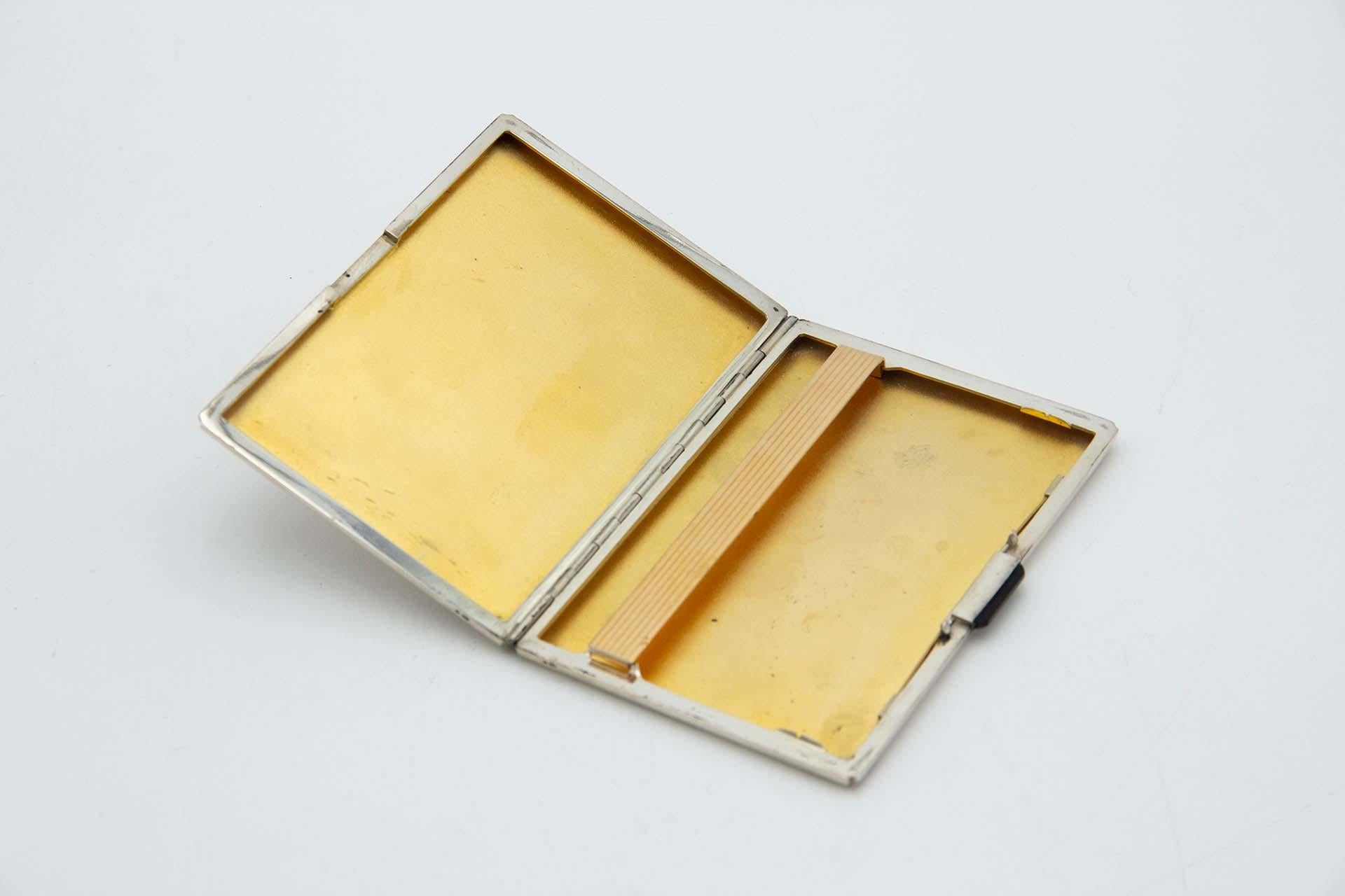 Description: Guilloche silver cigarette case with asymmetrical designs and gold interior. Metal: Silver. Origin: Portuguese. Brand: Eagle Head. Weight: 161.95 grams. Dimensions: 11.9cmx0.9cm. Content: 833/1000. Assay Mark: Yes, between 1938 and