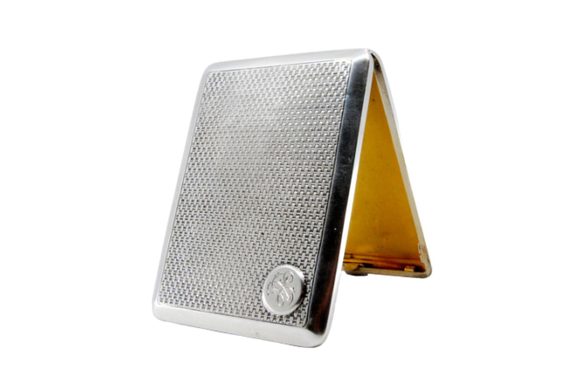 Beschreibung: Guillochiertes silbernes Zigarettenetui mit Monogrammkarte und goldener Innenausstattung und Scharnierdeckel. Metall: Silber. Herkunft: Portugiesisch. Marke: javali II Titel. Gewicht: 150,45 Gramm. Abmessungen: 11,4x1cm. Inhalt: