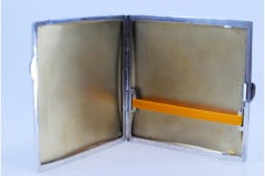 Etui à cigarettes en argent guilloché avec carte monogramme, intérieur doré et couvercle à charnière.