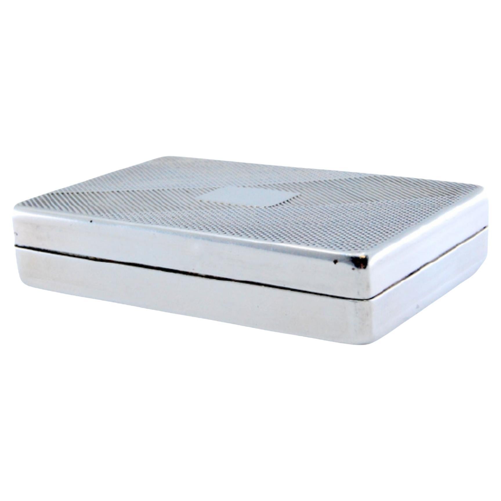 Guilloche silver pill box with a monogrammed card on the removable lid