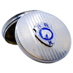 Guilloche silver pill box with bands at the top and BRK enamel on the hinged lid