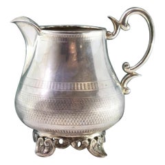 Guilloche silver wine jug with four scalloped feet