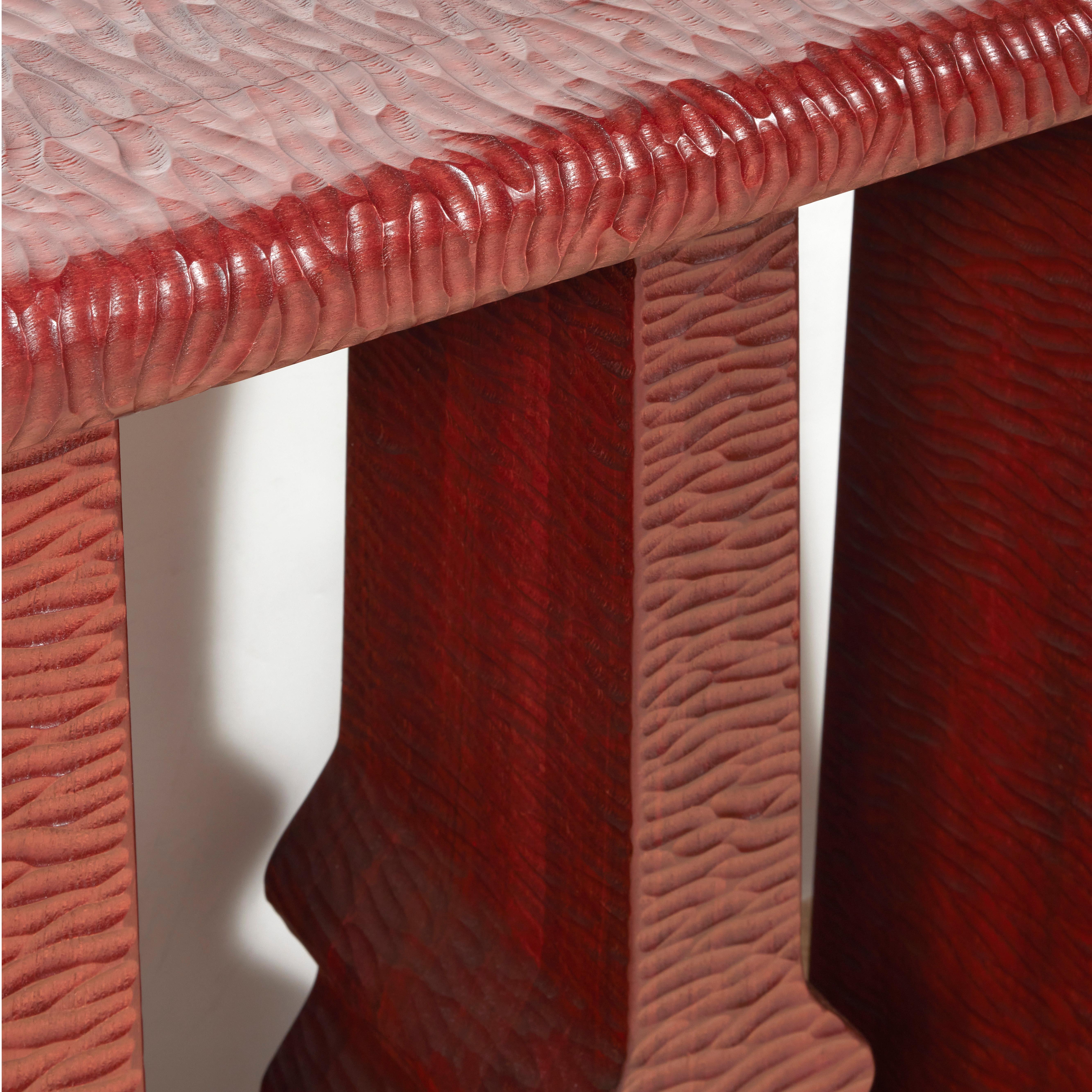 Five legged console table in red tinted walnut completely gouged by hand.