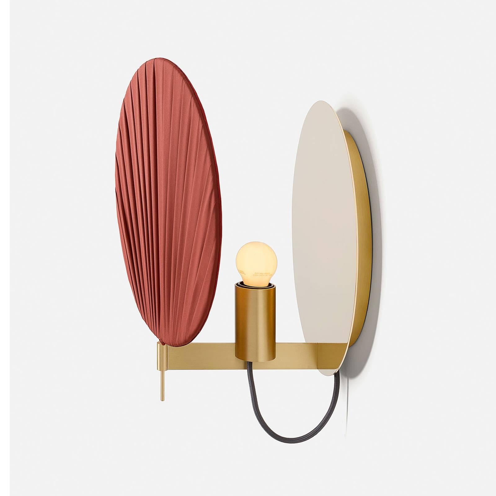 This elegant wall lamp is a celebration of modern design and exquisite craftsmanship. Its deep red shade is made up of multiple layers of pleated organza that create a stunning ambiance, diffusing the light that also reflects on the structure: a