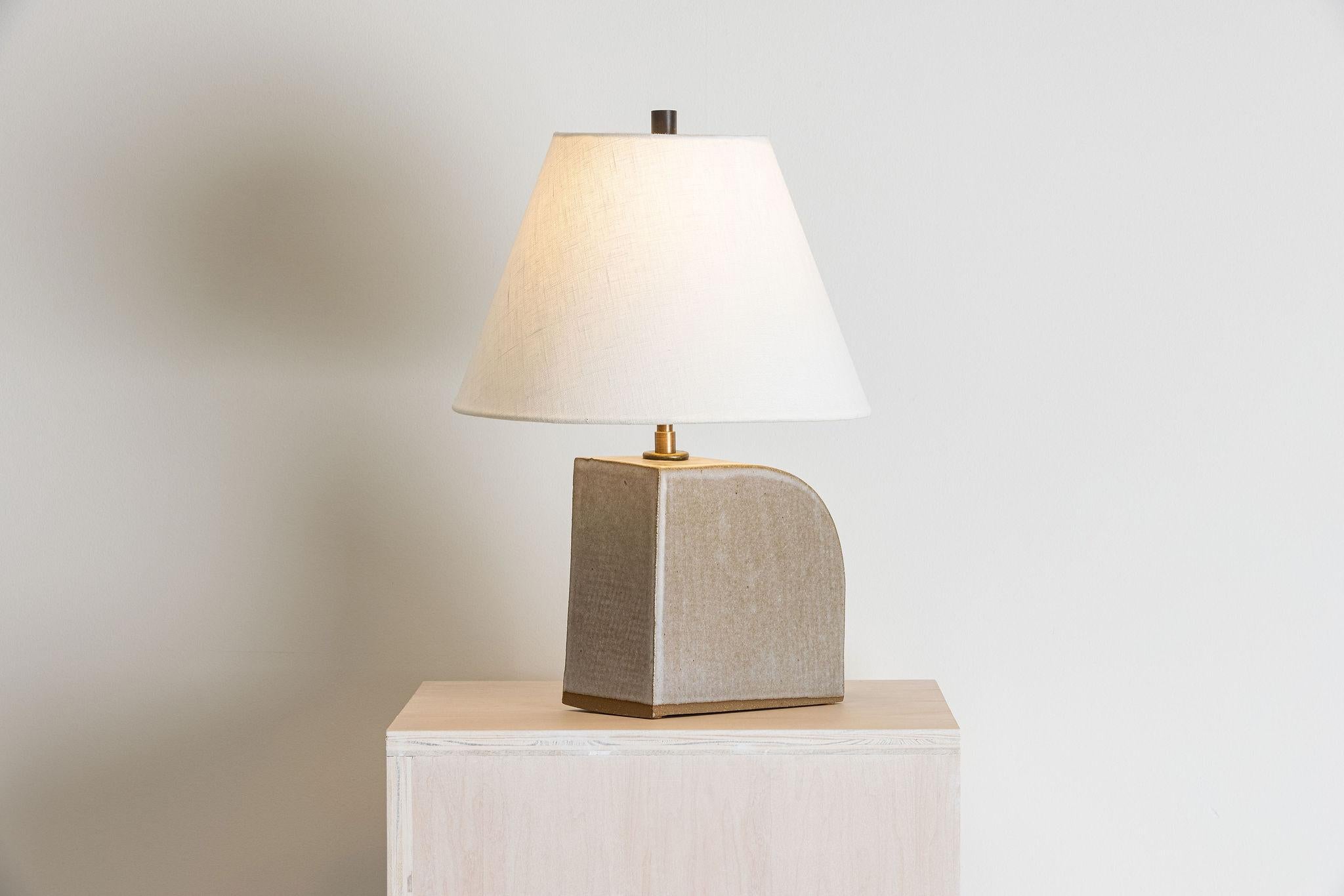 Our stoneware Gumbo Lamp is handcrafted using slab-construction techniques.

Finish

- Dipped glaze, pictured in parchment
- Antique brass fittings
- Twisted black-cloth cord
- Full-range dimmer socket
- Ochre burlap or black-linen