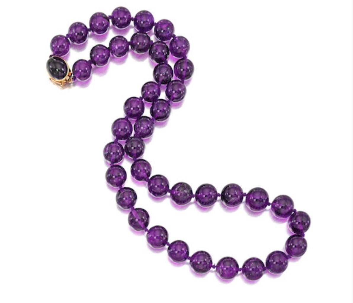 Gumps Amethyst bead Necklace comprising of line of graduated beads, measuring approximately 12.30 to 13.55mm to the bezel set amethyst clasp signed Gumps.
Mounted in 14k gold.
Length of the Amethyst Necklace is 23inches.