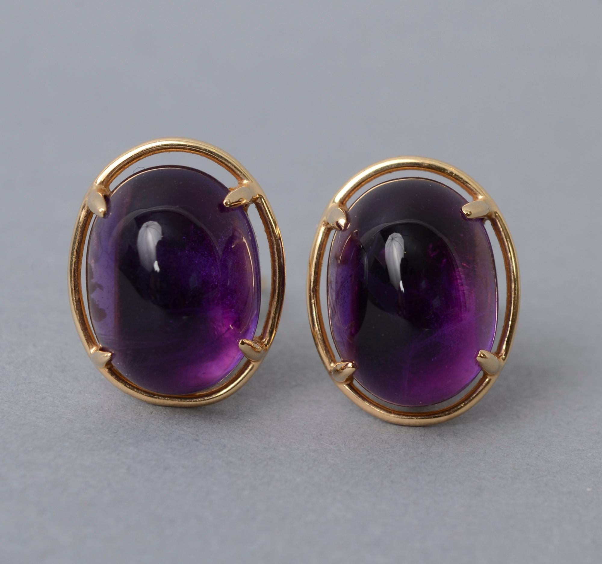 Amethyst and 14 karat gold earrings by Gump's. The oval cabochon stones are half an inch wide and 3/4 inch long. They are a wonderfully rich color. The stones are surrounded by a gold band and held with four prongs. Backs are clips and posts.