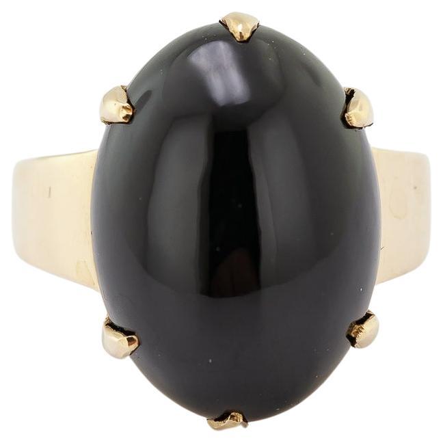 Featuring one oval black nephrite cabochon, 17.9 X 13.2 X 6.8 mm, six prong set in a 14k yellow gold mounting, 12 mm to 3.3 mm, marked GUMPS, 14K, size: 6.75, Gross Weight: 9.30 grams. 