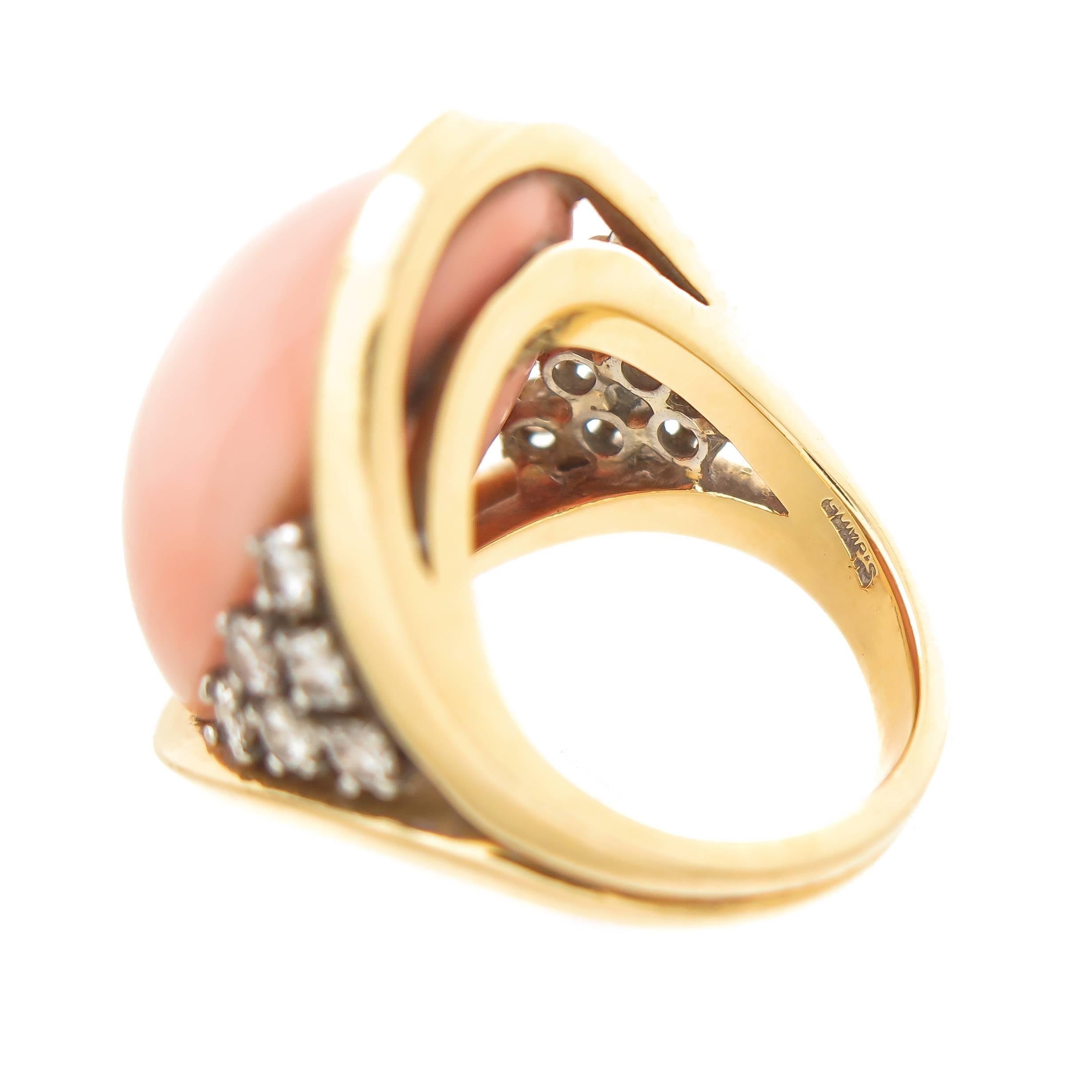 Circa 1980s Gumps 18K yellow Gold Ring, set with a Coral measuring 22 X 18 M.M. set on either side with Round Brilliant cut Diamonds totaling 1/2 Carat. The ring measures 1 1/16 inch in length across the top and is a finger size 6.
