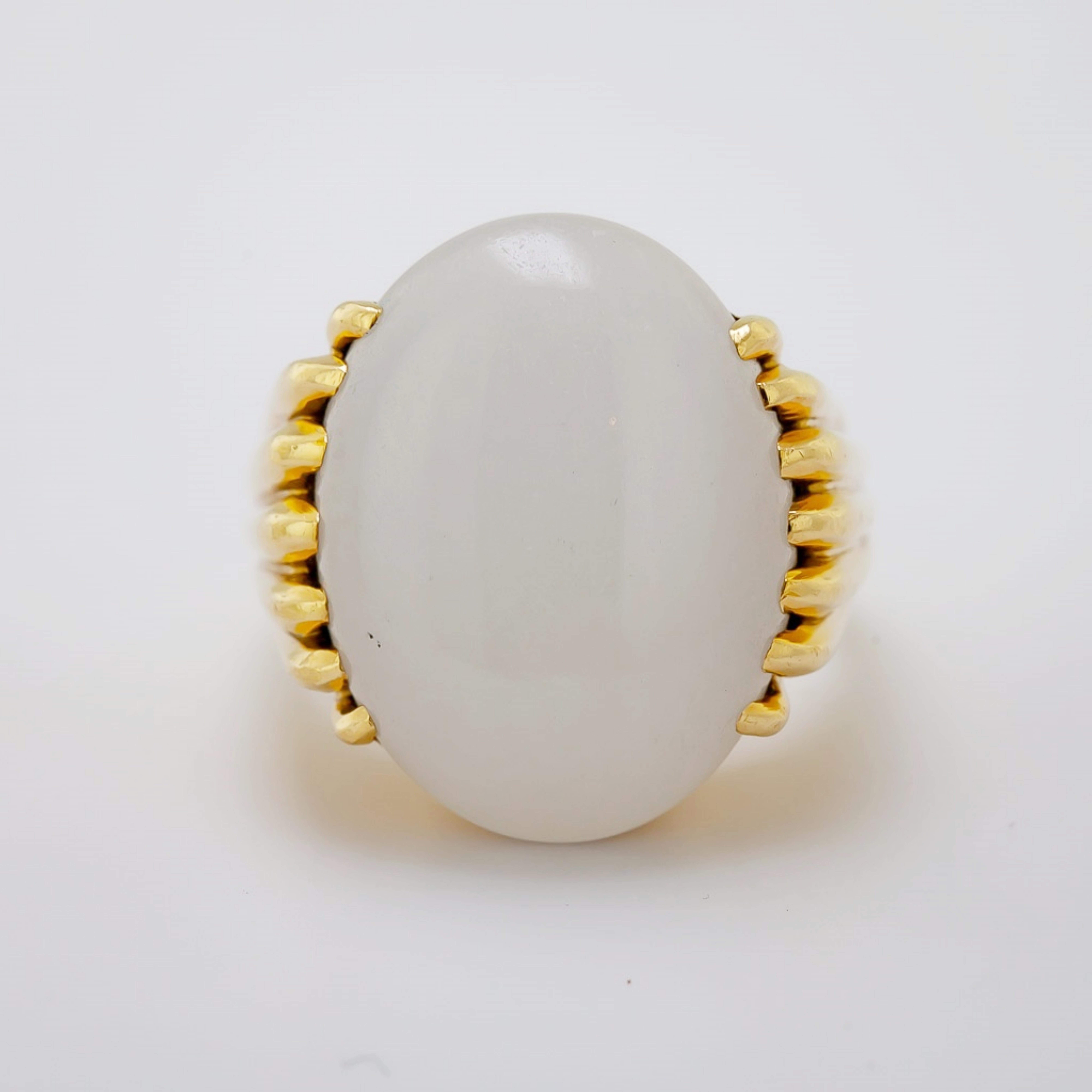 Featuring one natural white, semi translucent oval cabochon, 20.27 X 15.05 X 6.29 mm,
accompanied by a Mason Kay Report, stating No Dye or Impregnation Detected – ‘A’ Jade, fourteen prong set in an 18k yellow gold ring, marked GUMPS, size 6.5, Gross