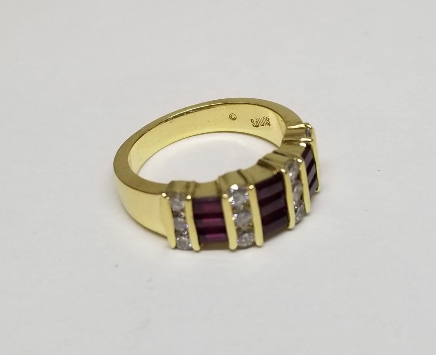 Der von Meister Gumps aus San Francisco entworfene Ring aus 18 Karat Gelbgold ist wunderschön.  Kanalbesatz mit abwechselnden Reihen von Rubinen im Baguetteschliff  und    runder Diamant  Der Ring misst an der breitesten Stelle 7,4 mm und verjüngt